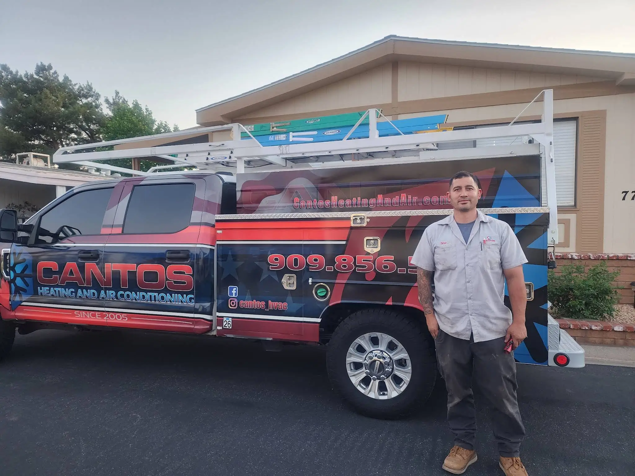 A man stands beside a truck displaying the word "Cantos" prominently on its side.